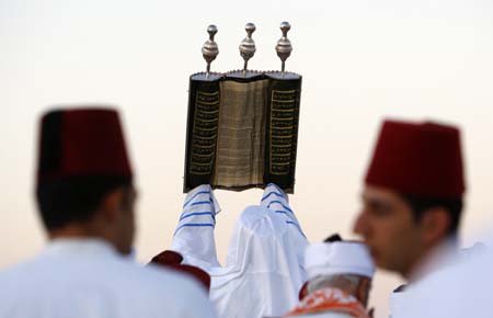 A Samaritan high priest raises the Torah scroll during a pilgrimage for the holy day of the Tabernacles or Sukkot, in Mount Gerizim near the West Bank town of Nablus, October 13, 2008. The Samaritan religion is an ancient form of Judaism believing in the One God of Israel, and the Torah, the first five books of the Bible. The whole community numbers about 700 people, half at Mount Gerizim and the others in Holon near Tel Aviv in Israel.