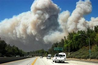 A cloud of smoke is blown over the freeway near Porter Ranch in Los Angeles on Monday Oct. 13,2008. [Mike Meadows/AP Photo]
