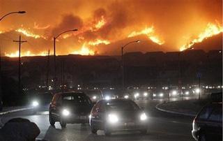 Traffic snakes up a road as residents flee their hillside homes during a fast moving, wind driven brush fire in the Sylmar area of the San Fernando Valley in Los Angeles, Monday, Oct. 13, 2008. [Dan Steinberg/AP Photo] 