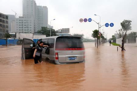 A woman trudges her way through the waterlogged street in Haikou, capital of south China's Hainan Province, Oct. 14, 2008. [Photo: Xinhua]
