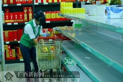 A worker in a supermarket of Nanning, south China's Guangxi Zhuang Autonomous Region, pulls off dairy products made before September.