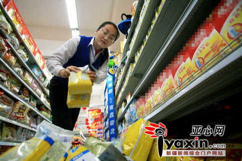 A worker in a supermarket of Urumqi, northwest China’s Xinjiang Uygur Autonomous Region, pulls off dairy products made before September 14, 2008. 