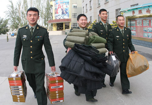 PLA soldiers donate clothes to Wuqia County which was hit by an early winter when the first snowfall on Tuesday left more than 400 families in the cold. (Photo on October 13)