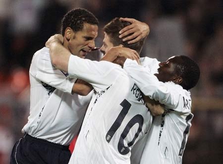 England's Rio Ferdinand (L) celebrates team's third goal against Belarus with teammates Steven Gerrard (C) and Shaun Wright-Phillips during their World Cup group 6 qualifying soccer match in Minsk, Belarus, Wednesday.[Xinhua/Reuters]