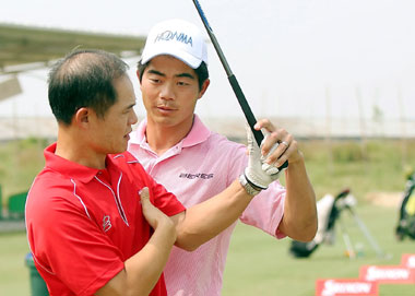 Fresh off his victory in India, Liang Wenchong (R)gives golf tips to an amateur player during a meeting with fans in Shunde, Guangdong Province, yesterday, ahead of 2008 China Classic in Guangzhou. 