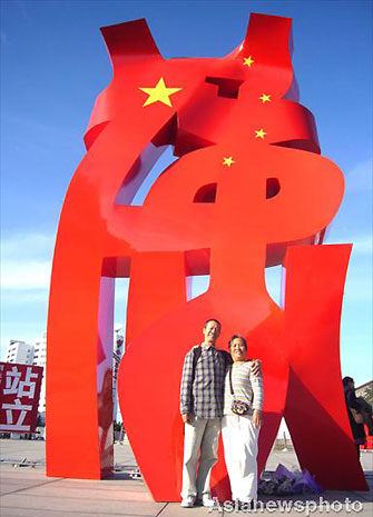 Visitors take photos in front of a sculpture on show at the China Millennium Monument Square in Beijing, October 15, 2008. A solo exhibition of 78 sculptures by Chinese artist Liu Yonggang started on Tuesday, China’s largest and longest modern sculpture exhibition. The show will last almost one month until November 12, 2008. [Asianewphoto]