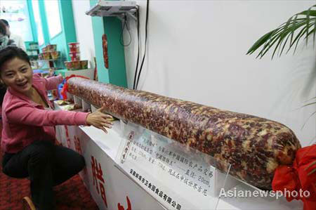 A visitor views a huge sausage at the 6th China International Agricultural Product Trade Fair in the National Agriculture Exhibition Center in Beijing, October 15, 2008. Many kinds of green and organic food are exhibited at this trade fair which opened on Wednesday. [Photo: Asianewsphoto] 
