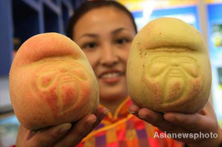 A woman shows Shou Tao (longevity peach) for visitors at the 6th China International Agricultural Product Trade Fair in the National Agriculture Exhibition Center in Beijing, October 15, 2008. [Photo: Asianewsphoto] 