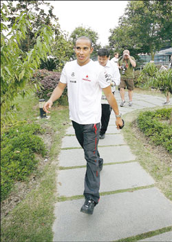 McLaren's British driver Lewis Hamilton walks to a hospitality suite at the Shanghai Circuit yesterday. 