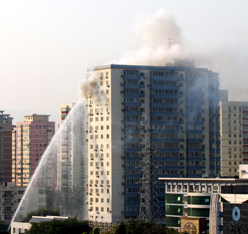Nearly 100 firefighters fought for two hours to extinguish a blaze at a Beijing apartment building on Thursday afternoon.