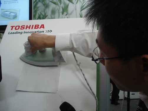 A technician from Toshiba irons a piece of paper. Words on the paper vanished after being heated. Thanks to “e-blue” technology, paper can be reused at least five times.