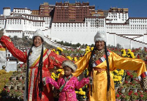 Three visitors from Qinghai Province take photos in front of the Potala Palace in Lhasa, capital of southwest China's Tibet Autonomous Region, on Sunday, October 19, 2008. According to the regional tourism bureau, various attractions and scenic spots in Tibet will offer discounted entrance fees from October 19 to April 20, 2009, in an effort to boost tourism. [Photo: Xinhua]