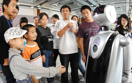 Visitors look at an intelligent robot during a robot expo in Hangzhou, East China&apos;s Zhejiang Province, October 18, 2008. [Xinhua] 