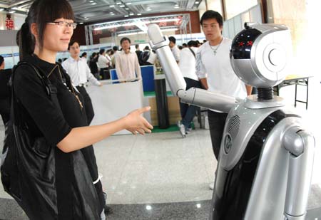 A girl tries to shake hands with an intelligent robot during a robot expo in Hangzhou, East China&apos;s Zhejiang Province, October 18, 2008. [Xinhua] 
