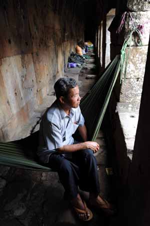 A refugee sits in the ancient ruins of the Preah Vihear Temple at the disputed border area of Cambodia and Thailand Oct. 19, 2008. [Xinhua]