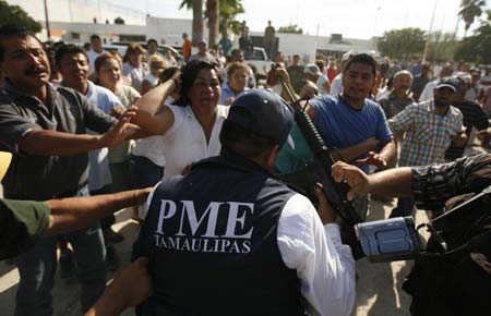 Relatives of inmates scuffle with state police agents outside a prison facility in the border city of Reynosa, northern Mexico October 20, 2008. At least 21 prisoners died in a jail riot in Mexico near the Texas border on Monday when inmates from rival gangs staged a gun battle and set fire to the building.