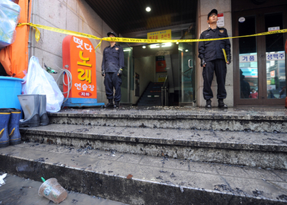 Policemen keep guard outside an inn where a South Korean man set fire and stabbed guests in Seoul Oct. 20, 2008. [Xinhua]