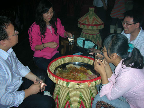Several customers have meal while sitting around a serving basket in Beijing's First Ethiopian Restaurant on October 17, 2008. [Photo: CRIENGLISH.com] 