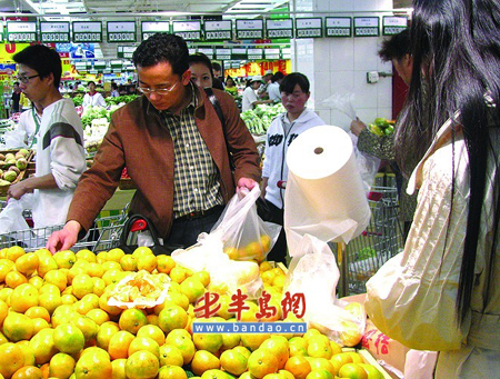 A man selects tangerine in supermarket in Qingdao, Shandong Province, in east China. 