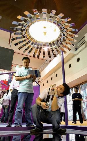 A 'green' flower lamp draws close inspection at the Shanghai International Creative Industry Expo, which opened yesterday and is scheduled for four days. When household energy use has been low, the lamp blooms as a reward for good eco-behavior.