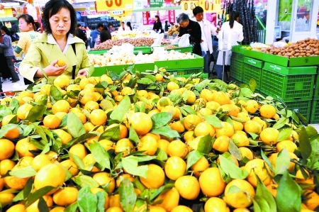 People buy oranges in a fruit market in Zhengzhou, cental China's Henan Province, on October 22, 2008. 