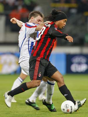 Heerenveen's Michael Dingsdag (L) challenges AC Milan's Ronaldinho during their UEFA Cup soccer match in Heerenveen October 23, 2008.[Xinhua/Reuters]