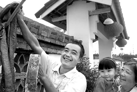 Villager Zhao Guangdong hangs up a string of small firecrackers to celebrate his family's move to a new house in Mianyang, Sichuan, yesterday. Mianyang was badly hit by the May 12 earthquake.