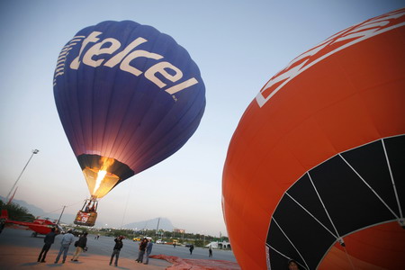 A worker lights a burner inside a hot air balloon as it is prepared for flight as part of the Santa Lucia International Festival in Monterrey, northern Mexico October 24, 2008. [Agencies] 