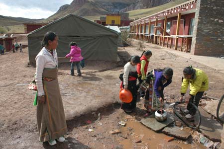 Girls carry water in front of the Lajia girl school in Golog Tibetan Autonomous Prefecture of Qinghai Province on Oct. 17, 2008. The girl school founded in 2005 has made more than 300 Tibetan girls fulfill their 