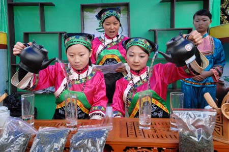 Young ladies in costumes of minority groups perform tea ceremony during a tea promotion activity held in Guiyang, southwest China's Guizhou Province, Oct. 24, 2008. More than 100 tea factories and traders from 38 counties in Guizhou Province exhibited their tea products here Friday.[Xinhua Photo/ Photomall]