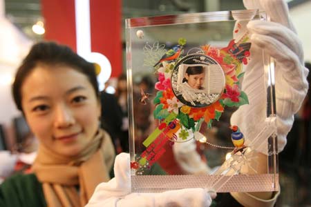 A working staff shows a souvenir coin that was made to order during 2008 International Stamps snd Coins Exposition held in Beijing, Oct. 24, 2008. The exposition was opened here on Friday with collections of stamps, coins and souvenir badges from all over the world exhibited.[Xinhua]