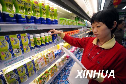A worker in the Huaite Branch of the Beiguo Supermarket in Shijiazhung, Hebei Province, tests the milk powder on sale according to a test report on September 27, 2008.