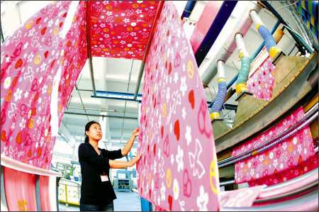 A worker checks the cloth carefully in a workshop of the Xindongxu Printing and Dyeing Co. Ltd., Zhangjiagang City, north China's Hebei Province, on October 22. The city enjoys a high growth of textile products this year, with the export volume reaching US$70 million, up 12 percent over the period of last year. 