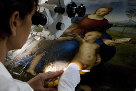 Fine arts technician Patrizia Riitana uses special optics to view Italian artist Raphael's 1506 oil-on-wood painting 'Madonna of the Goldfinch' at a laboratory in Florence October 23, 2008. 
