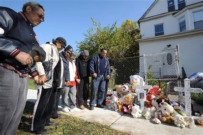 A group led by community activist Andrew Holmes right, pray at a makeshift memorial outside the home belonging to the family of Oscar-winning actress Jennifer Hudson in Chicago, Sunday, Oct. 26, 2008. Hudson's mother Darnell Donerson and brother Jason Hudson were found dead.
