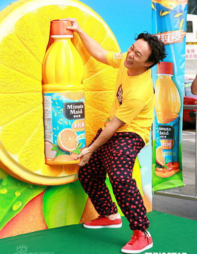 Eason Chan tries to move a large juice bottle at a promo for a juice brand in Hong Kong, October 27, 2008.