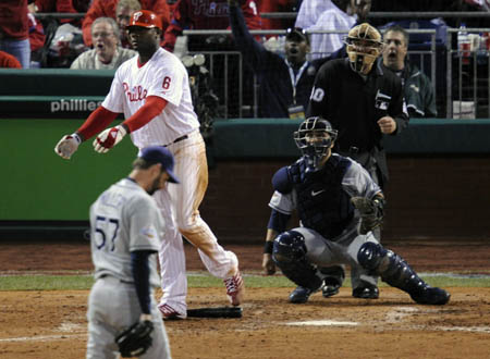 Philadelphia Phillies Ryan Howard (2nd L) hits a two-run home run off of Tampa Bay Rays pitcher Trever Miller (L) as catcher Dioner Navarro (2nd R) and umpire Tom Hallion (R) watch during the eighth inning in Game 4 of Major League Baseball's World Series in Philadelphia, October 26, 2008.