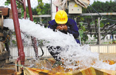 Guangdong provincial hydrological surveying workers successfully pumped underground water in Nanzhuang Town of Foshan City on July 23, 2008. The daily exploitation volume is estimated to reach 448,000 cubic meters which can meet the need of 5 million residents. (Photo: Guangdong Daily News)