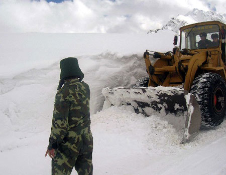 A heavy snow, which began to fall on Sunday in southwest China's Tibet, has left two people missing and blocked roads in many places. Armed police are struggling to clear roads to restore traffic.
