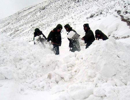 A heavy snow, which began to fall on Sunday in southwest China's Tibet, has left two people missing and blocked roads in many places. Armed police are struggling to clear roads to restore traffic. 