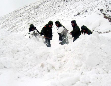 Armed police struggle to clear roads to restore traffic in southwest China's Tibet Autonomous Region on October 27, 2008. Three days of big snow has blocked the only road that leads to Zayu County, a fertile area in southeastern Tibet. [Photo: Xinhua] 