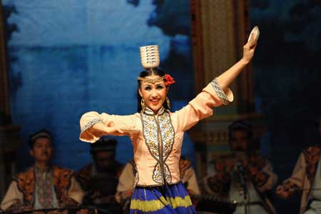 An actress from China's Xinjiang Mukam Art Troupe shows Chinese ethnic culture during her dance in Doha, Qatar Oct. 26, 2008.