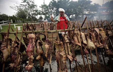 Paraguayans barbeque beef during an attempt to create the world&apos;s biggest barbecue in Mariano Roque Alonso near Asuncion Oct. 26, 2008. In the attempt to get the Guinness World Record for the &apos;Biggest barbeque in the World&apos;, more than 30,000 people grilled 28,000 kilograms of beef on fires covering an area 60 m wide by 100 m long. [Xinhua/Reuters]