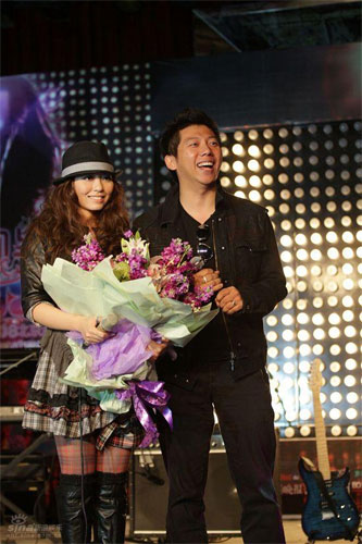 Hu Haiquan (right) from the pop duo Yu Quan, presents a bunch of flowers to Jane Zhang, who held a press conference for her upcoming solo tour, October 27, 2008. 