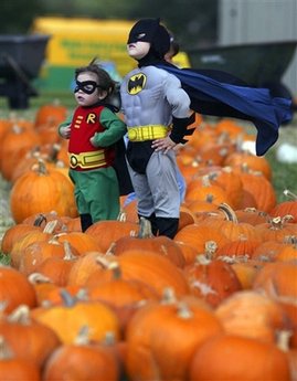 Westin Smith, 2, dressed as Robin, and Shepherd Smith, 5, dressed as Batman, right, pose for pictures that their mother Cori Smith, not shown, was taking of them at the pumpkin patch behind Alamo Heights United Methodist Church in San Antonio on Wednesday October 22, 2008. [Agencies]