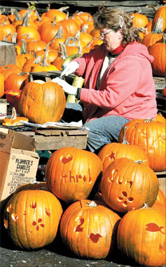 An Ellie's Farm Market employee carves one of the more than 1,000 pumpkins that will be used for the store's 31st annual Halloween pumpkin display in Berlin October 24, 2008. Halloween is a big festival for American children and youths, but Europeans seem to be catching up with them. [Agencies]