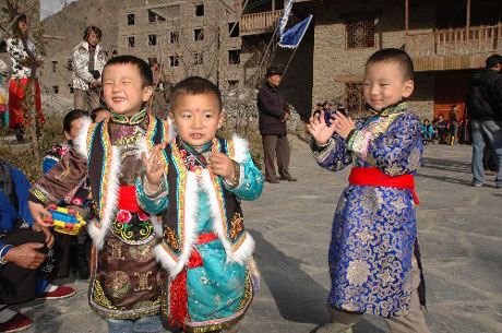 Children wear ethic costumes to welcome the New Year in the Qiang calendar at Li county of Aba Tibetan and Qiang autonomous prefecture, Southwest China’s Sichuan province, October 28, 2008. [Xinhua]