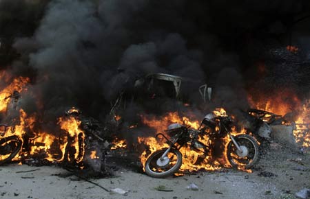 Damaged vehicles burn after a bomb blast in Guwahati, the main city of India&apos;s troubled northeastern Assam state, Oct. 30, 2008. [Xinhua]