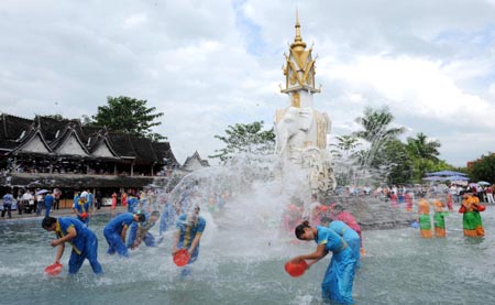 Dai ethnic girls and tourists play during a water-splashing festival in Dai Autonomous Prefecture of Xishuangbanna, southwest China&apos;s Yunnan Province Oct. 30, 3008. 