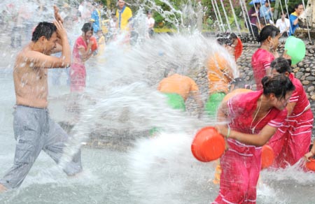 Dai ethnic girls and tourists play during a water-splashing festival in Dai Autonomous Prefecture of Xishuangbanna, southwest China's Yunnan Province Oct. 30, 3008. [Xinhua] 